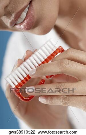 Close-up of a young woman cleaning her fingernails with a nail brush View Large Photo Image Stock Image - Close-up of a young woman cleaning her fingernails with a nail brush. Fotosearch