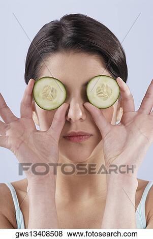 Close-up of a young woman covering her eyes with cucumber slices View Large Photo Image Stock Photo - Close-up of a young woman covering her eyes with cucumber slices. Fotosearch