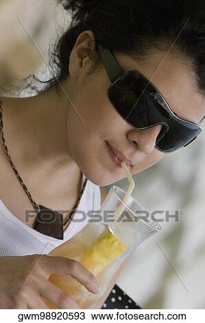 Close-up of a young woman drinking a glass of juice View Large Photo Image Stock Image - Close-up of a young woman drinking a glass of juice. Fotosearch