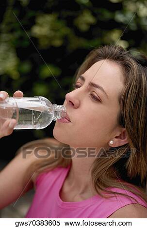 Stock Photography - Close-up of a young woman drinking water from a water bottle. Fotosearch
