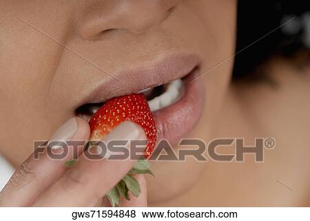 Close-up of a young woman eating a strawberry View Large Photo Image Stock Photo - Close-up of a young woman eating a strawberry. Fotosearch