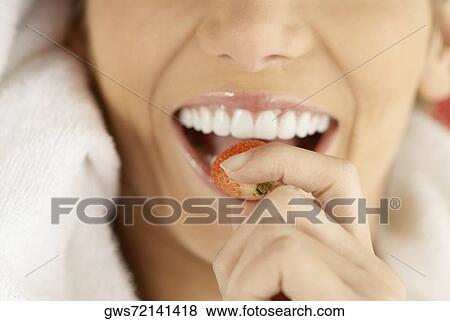 Close-up of a young woman eating a strawberry View Large Photo Image Stock Photo - Close-up of a young woman eating a strawberry. Fotosearch