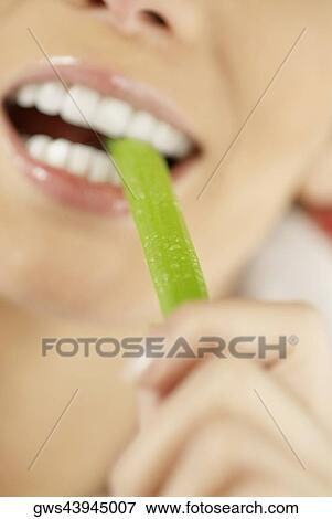 Close-up of a young woman eating an asparagus View Large Photo Image Stock Photo - Close-up of a young woman eating an asparagus. Fotosearch