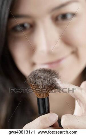 Close-up of a young woman holding a blush brush View Large Photo Image Stock Image - Close-up of a young woman holding a blush brush. Fotosearch