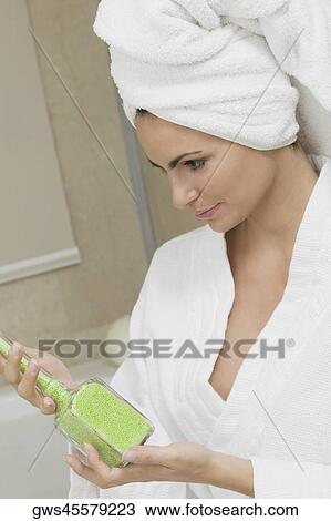 Close-up of a young woman holding a bottle of bath crystals View Large Photo Image Stock Image - Close-up of a young woman holding a bottle of bath crystals. Fotosearch