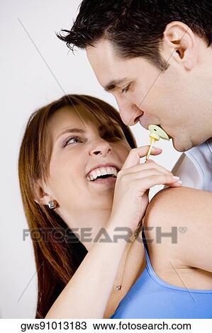 Close-up of a young woman holding a pacifier in a mid adult man's mouth View Large Photo Image Stock Image - Close-up of a young woman holding a pacifier in a mid adult man's mouth. Fotosearch