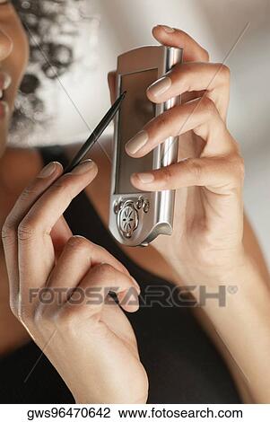 Close-up of a young woman holding a mobile phone and a stylus View Large Photo Image Stock Image - Close-up of a young woman holding a mobile phone and a stylus. Fotosearch