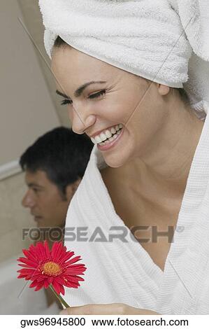 Close-up of a young woman holding a flower View Large Photo Image Stock Image - Close-up of a young woman holding a flower. Fotosearch