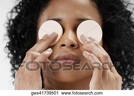 Close-up of a young woman holding powder puffs over her eyes View Large Photo Image Stock Image - Close-up of a young woman holding powder puffs over her eyes. Fotosearch