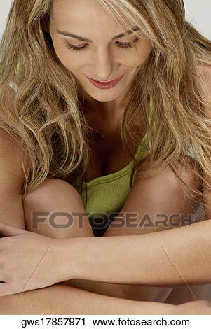 Close-up of a young woman hugging her knees View Large Photo Image Stock Image - Close-up of a young woman hugging her knees. Fotosearch