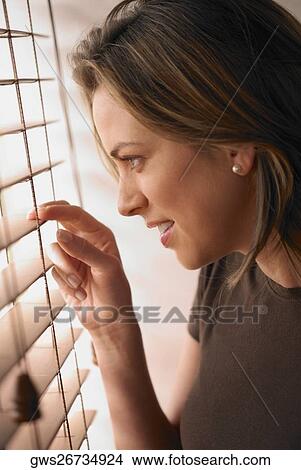 Close-up of a young woman looking out of a window View Large Photo Image Picture - Close-up of a young woman looking out of a window. Fotosearch