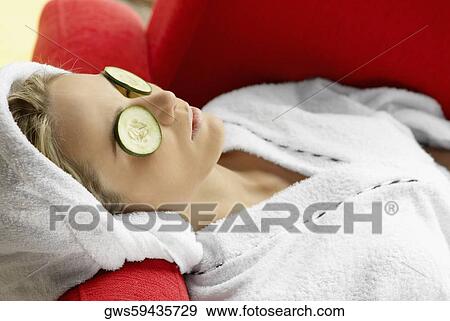 Close-up of a young woman resting with cucumber slices on her eyes View Large Photo Image Stock Photo - Close-up of a young woman resting with cucumber slices on her eyes. Fotosearch