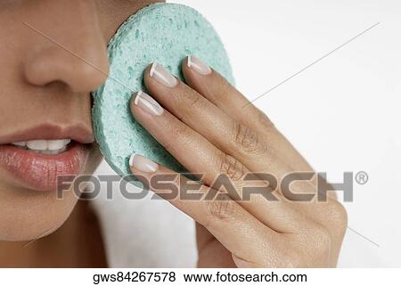 Close-up of a young woman scrubbing her face with a sponge View Large Photo Image Stock Photo - Close-up of a young woman scrubbing her face with a sponge. Fotosearch