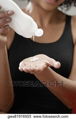 Close-up of a young woman squeezing moisturizer on her hand View Large Photo Image Stock Image - Close-up of a young woman squeezing moisturizer on her hand. Fotosearch