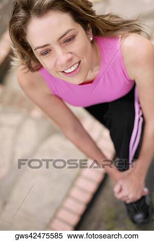 Stock Photography - Close-up of a young woman stretching her leg. Fotosearch