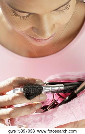 Close-up of a young woman taking make-up brushes from her purse View Large Photo Image Stock Image - Close-up of a young woman taking make-up brushes from her purse. Fotosearch