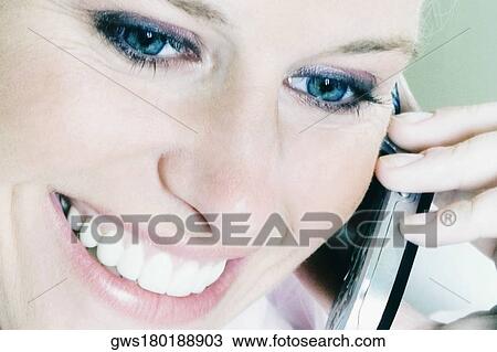 Stock Image - Close-up of a young woman talking on a mobile phone. Fotosearch