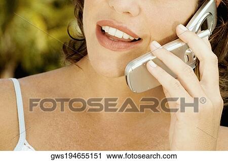 Close-up of a young woman talking on a mobile phone View Large Photo Image Stock Image - Close-up of a young woman talking on a mobile phone. Fotosearch