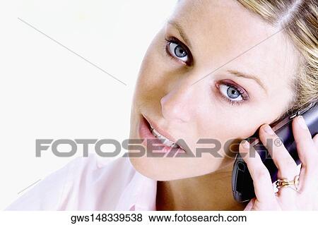 Close-up of a young woman talking on a mobile phone View Large Photo Image Stock Photo - Close-up of a young woman talking on a mobile phone. Fotosearch
