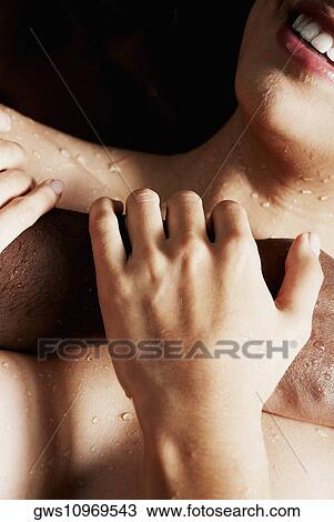 Stock Image - Close-up of a young woman touching a young man's hand. Fotosearch