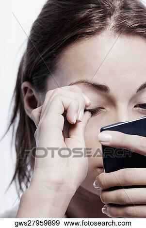 Close-up of a young woman touching her eye View Large Photo Image Stock Photo - Close-up of a young woman touching her eye. Fotosearch