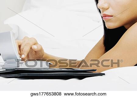 Close-up of a young woman using a calculator View Large Photo Image Stock Photo - Close-up of a young woman using a calculator. Fotosearch