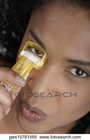 Close-up of a young woman using an eyelash curler View Large Photo Image Stock Photography - Close-up of a young woman using an eyelash curler. Fotosearch