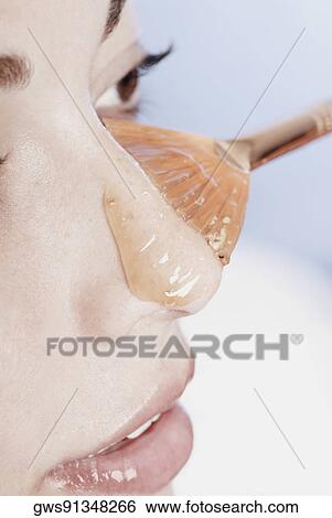 Close-up of a young woman with a facial mask on her face View Large Photo Image Stock Photograph - Close-up of a young woman with a facial mask on her face. Fotosearch
