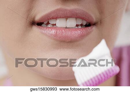 Close-up of a young woman with a toothbrush in front of her mouth View Large Photo Image Stock Image - Close-up of a young woman with a toothbrush in front of her mouth. Fotosearch