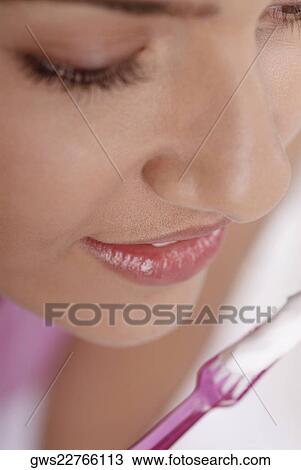 Close-up of a young woman with a toothbrush in front of her mouth View Large Photo Image Stock Image - Close-up of a young woman with a toothbrush in front of her mouth. Fotosearch