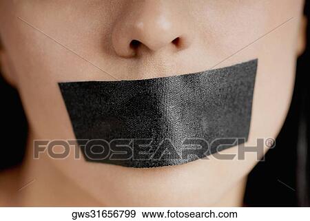 Close-up of a young woman with adhesive tape over her mouth View Large Photo Image Stock Photo - Close-up of a young woman with adhesive tape over her mouth. Fotosearch