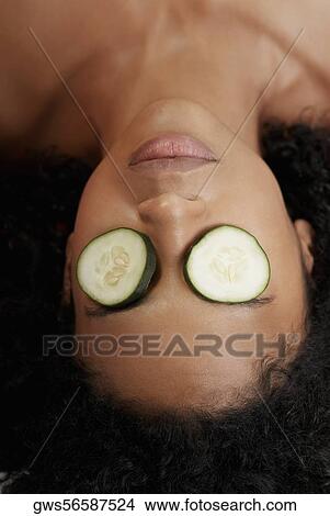 Close-up of a young woman with cucumber slices on her eyes View Large Photo Image Picture - Close-up of a young woman with cucumber slices on her eyes. Fotosearch