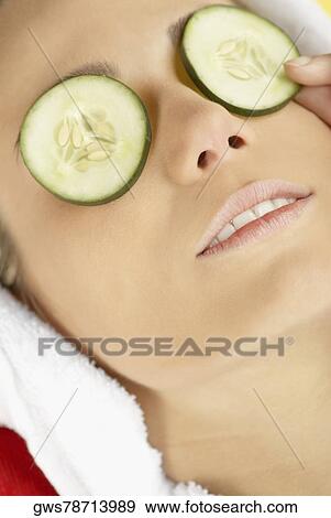 Close-up of a young woman with cucumber slices on her eyes View Large Photo Image Stock Photo - Close-up of a young woman with cucumber slices on her eyes. Fotosearch