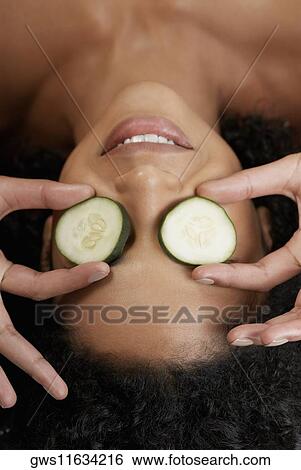 Close-up of a young woman with cucumber slices on her eyes View Large Photo Image Stock Photograph - Close-up of a young woman with cucumber slices on her eyes. Fotosearch