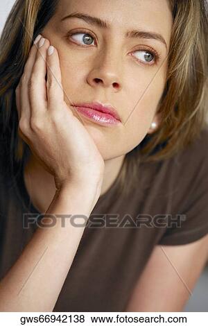 Close-up of a young woman with her hand on her chin View Large Photo Image Stock Photo - Close-up of a young woman with her hand on her chin. Fotosearch