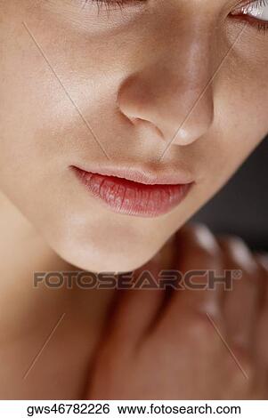Close-up of a young woman with her hand on her shoulder View Large Photo Image Stock Photograph - Close-up of a young woman with her hand on her shoulder. Fotosearch