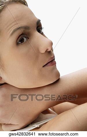 Close-up of a young woman with her hands behind her head View Large Photo Image Stock Image - Close-up of a young woman with her hands behind her head. Fotosearch