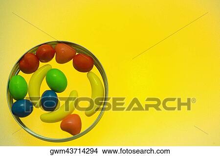 Close-up of assorted candies on a yellow background View Large Photo Image Picture - Close-up of assorted candies on a yellow background. Fotosearch
