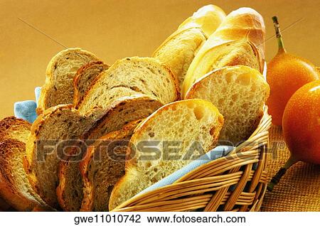 Stock Image - Close-up of bread in a basket with fruits. Fotosearch