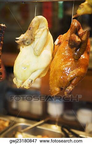 Stock Photo - Close-up of chickens hanging in a restaurant. Fotosearch