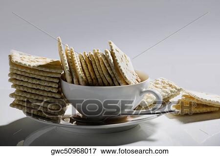 Close-up of crackers in a plate with a cup of tea View Large Photo Image Stock Photo - Close-up of crackers in a plate with a cup of tea. Fotosearch