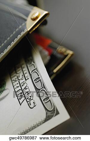 Stock Photo - Close-up of one hundred dollar bill with a purse. Fotosearch