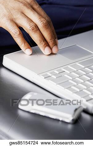 Close-up of person's hand using a laptop View Large Photo Image Picture - Close-up of person's hand using a laptop. Fotosearch