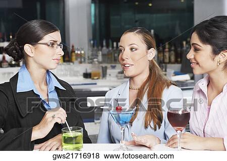 Close-up of three businesswomen talking in a bar View Large Photo Image Stock Photo - Close-up of three businesswomen talking in a bar. Fotosearch