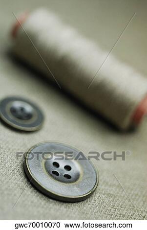 Close-up of two buttons with a spool of thread View Large Photo Image Stock Image - Close-up of two buttons with a spool of thread. Fotosearch