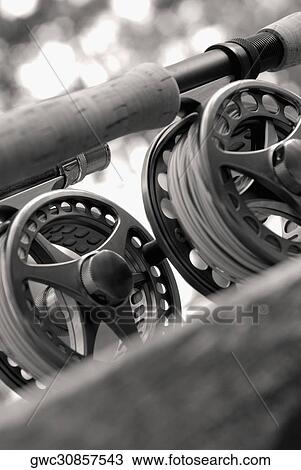 Stock Image - Close-up of two fishing reels and a fishing rod. Fotosearch