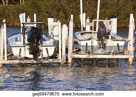 Stock Photography - Close-up of two motorboats on wooden platforms. Fotosearch