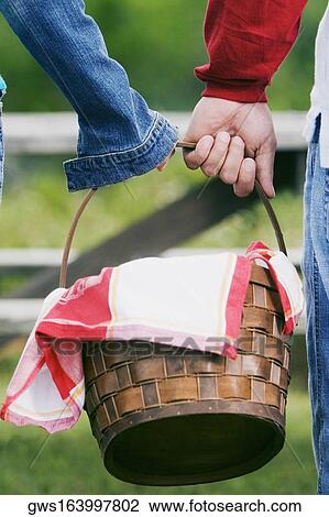 Close-up of two people carrying a picnic basket View Large Photo Image Stock Image - Close-up of two people carrying a picnic basket. Fotosearch