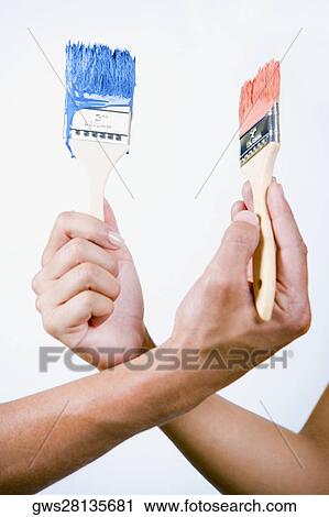 Close-up of two people's hands holding paintbrushes View Large Photo Image Stock Image - Close-up of two people's hands holding paintbrushes. Fotosearch