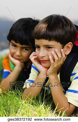 Close-up of two schoolboys lying on the grass View Large Photo Image Stock Image - Close-up of two schoolboys lying on the grass. Fotosearch